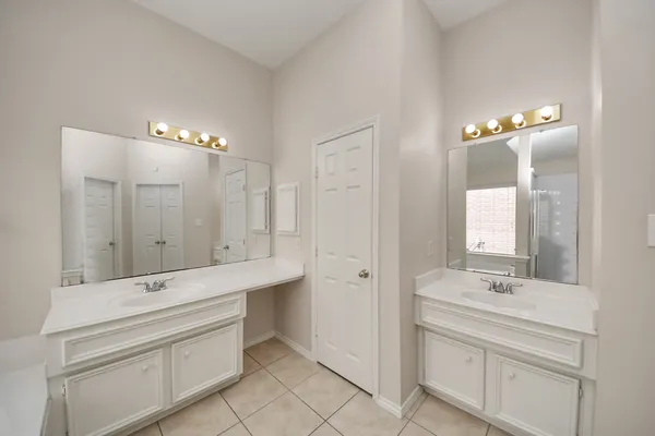 a bathroom with a double vanity sink mirror and