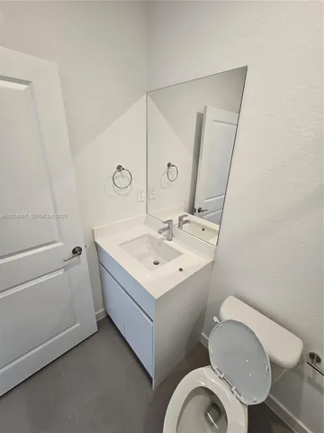 a bathroom with a sink toilet and a mirror