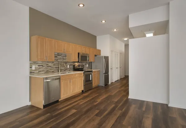 a kitchen with stainless steel appliances kitchen island granite countertop a sink and cabinets