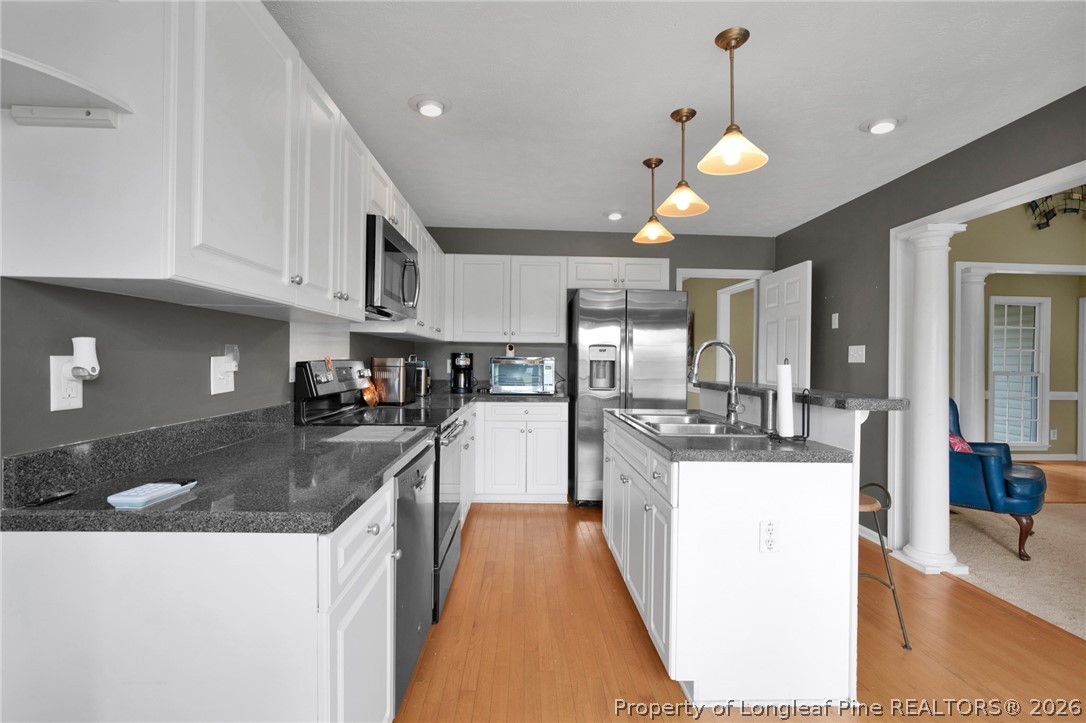 73 Timberlake Drive Clinton, NC 28328 - Photo 15 of 37 a kitchen with stainless steel appliances granite countertop a sink a stove and a wooden cabinets