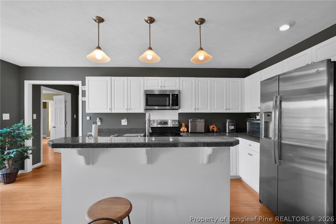 73 Timberlake Drive Clinton, NC 28328 - Photo 18 of 37 a kitchen with stainless steel appliances granite countertop a refrigerator a sink dishwasher a stove and a refrigerator with wooden floor