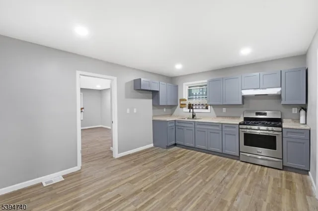 a kitchen with stainless steel appliances granite countertop a stove a sink dishwasher and a refrigerator