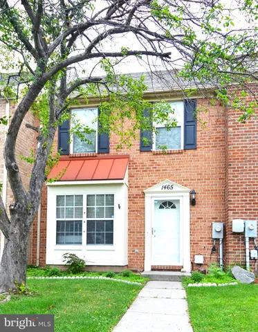front of a house with a yard and large trees