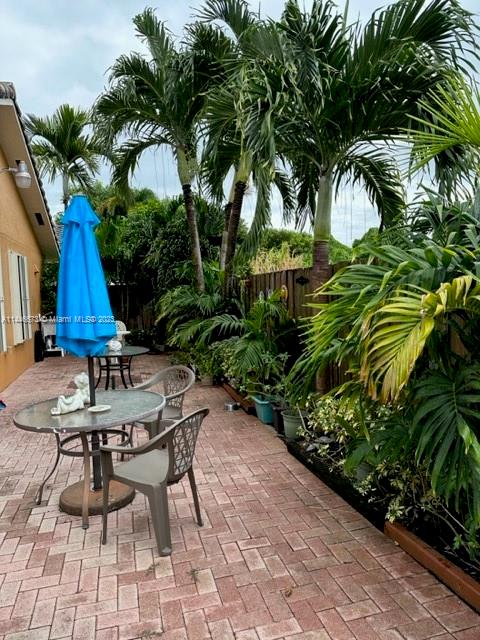 14636 Southwest 115th Terrace Miami, FL 33186 - Photo 11 of 12 a backyard of a house with table and chairs plants