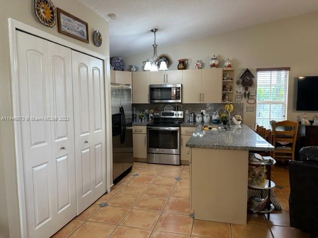 14636 Southwest 115th Terrace Miami, FL 33186 - Photo 7 of 12 a kitchen with kitchen island a counter space a sink a stove and refrigerator