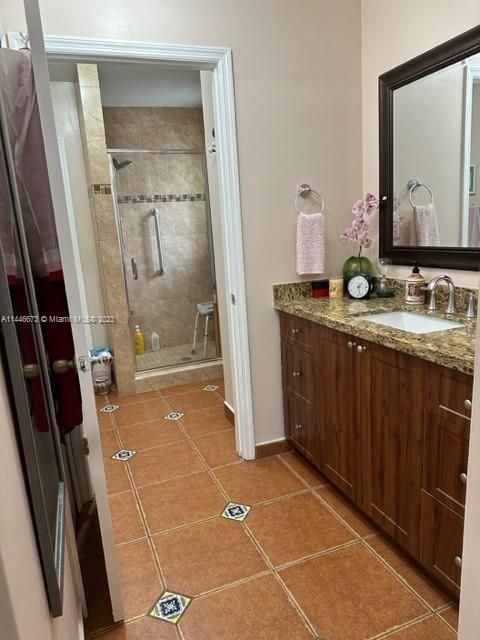 14636 Southwest 115th Terrace Miami, FL 33186 - Photo 10 of 12 a bathroom with a granite countertop sink a mirror and a shower