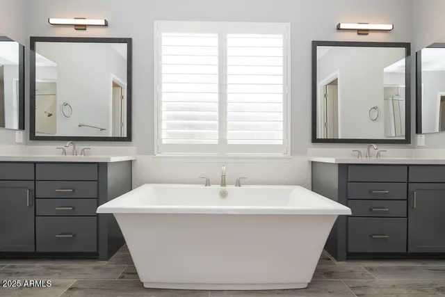 a white bath tub sitting in a bathroom next to a window