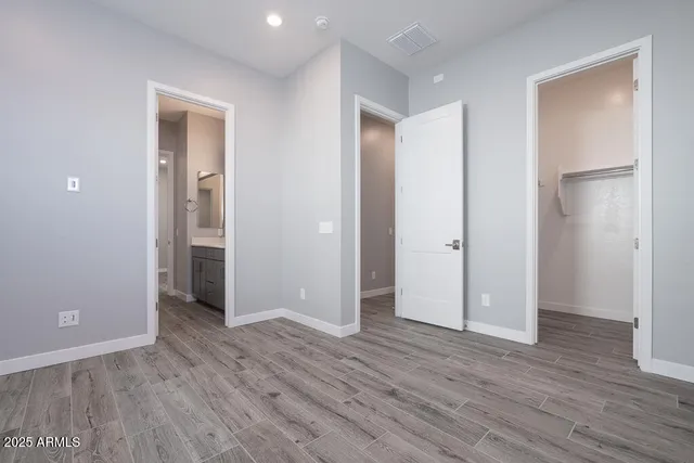 an empty room with wooden floor & closet area