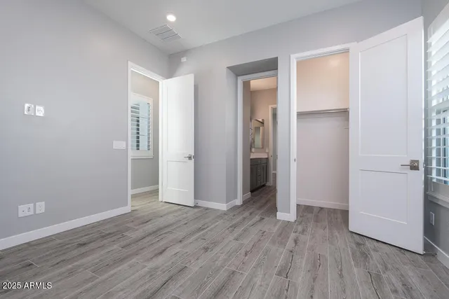 an empty room with wooden floor & closet area