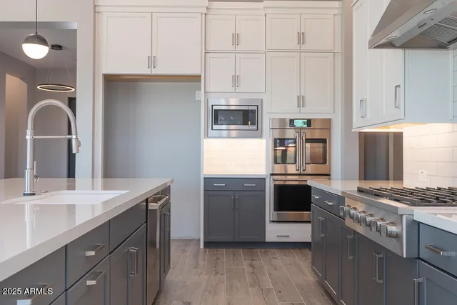 a kitchen with stainless steel appliances a stove sink and cabinets