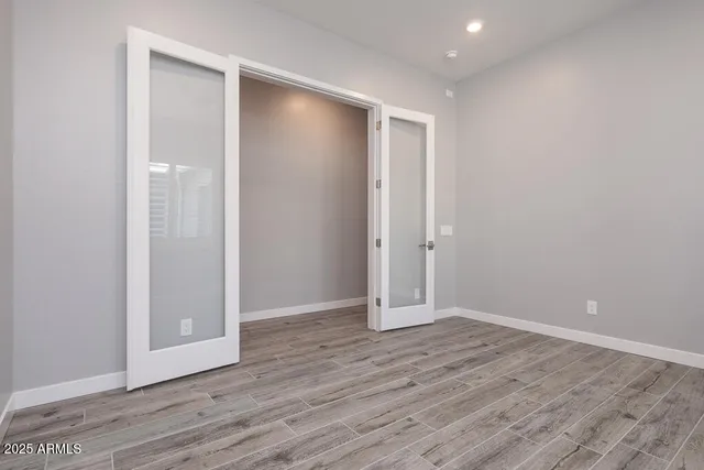 an empty room with wooden floor and entrance