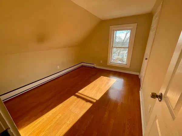 a view of a room with wooden floor and a window