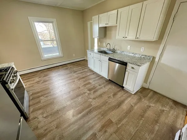 a kitchen with granite countertop white cabinets and white appliances