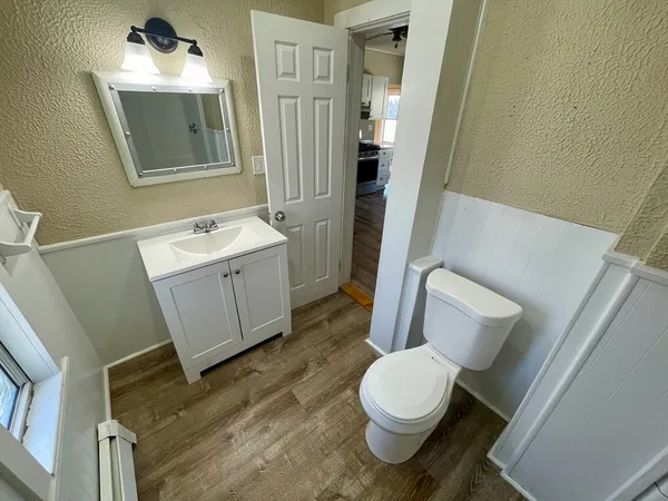 a bathroom with a toilet sink and mirror