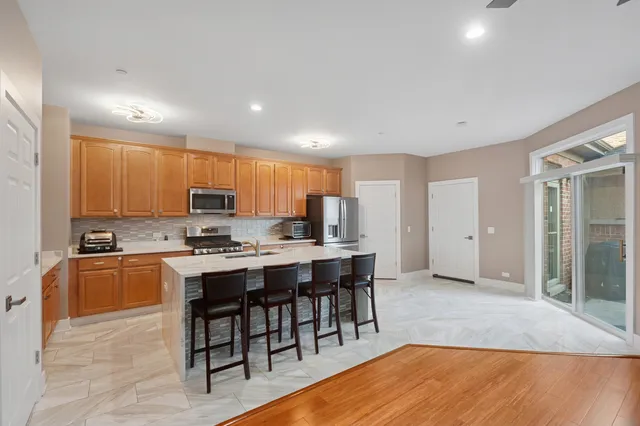 a large kitchen with kitchen island a sink table and chairs