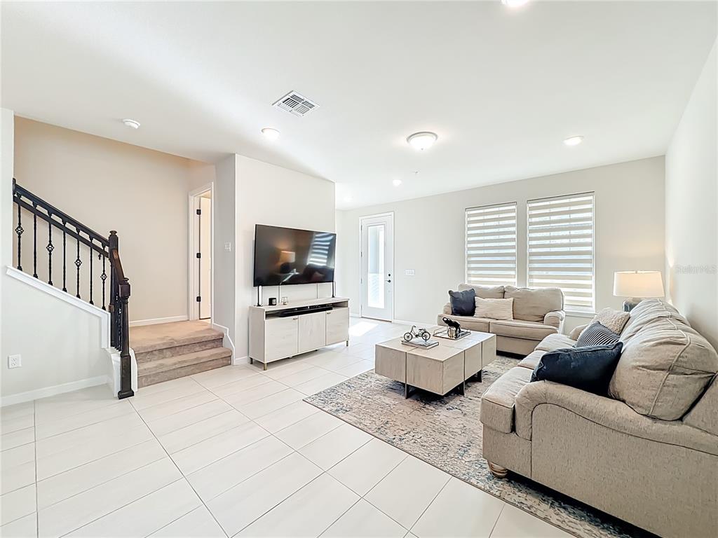 10976 Leafshore Loop Orlando, FL 32829 - Photo 12 of 70 a living room with furniture and a flat screen tv