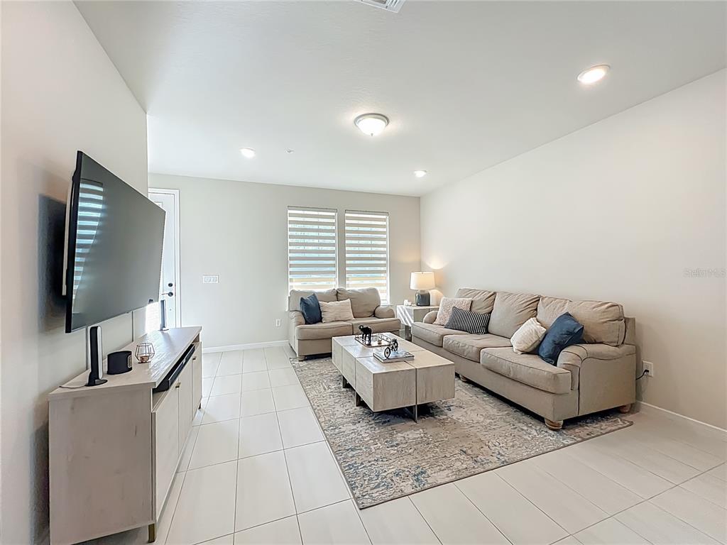 10976 Leafshore Loop Orlando, FL 32829 - Photo 13 of 70 a living room with couches and a flat screen tv