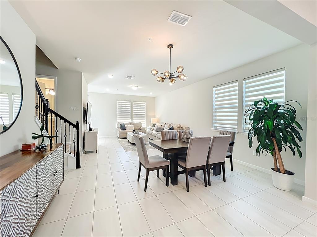 10976 Leafshore Loop Orlando, FL 32829 - Photo 19 of 70 a dining room with furniture potted plants and wooden floor