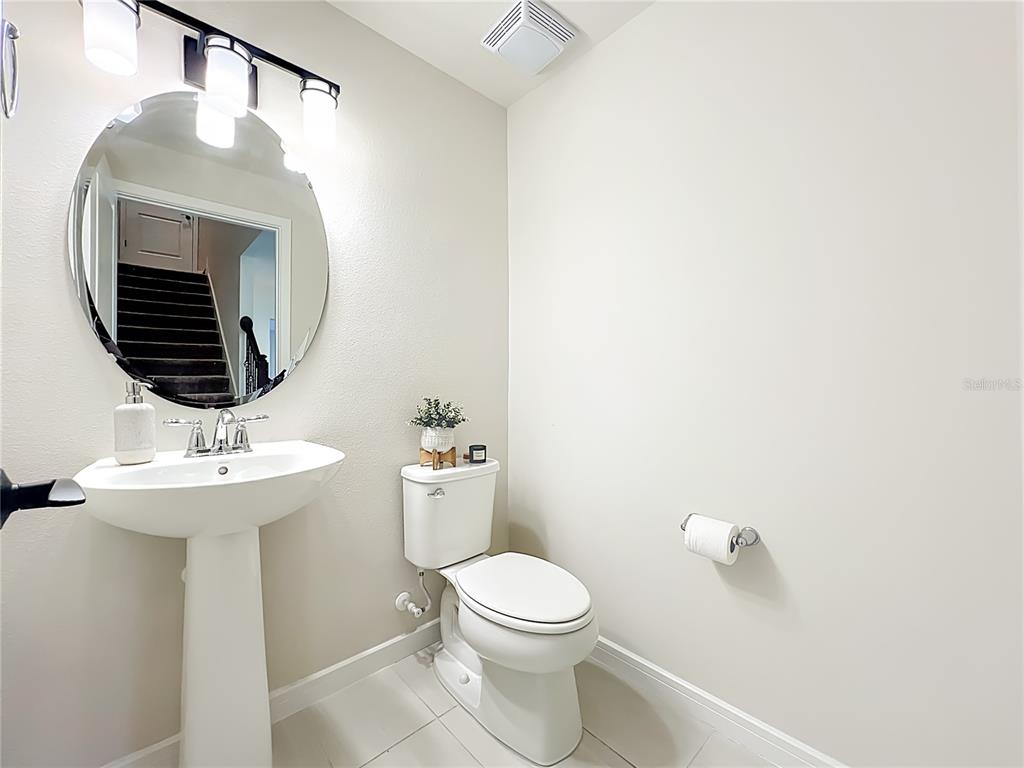 10976 Leafshore Loop Orlando, FL 32829 - Photo 29 of 70 a bathroom with a toilet sink and mirror