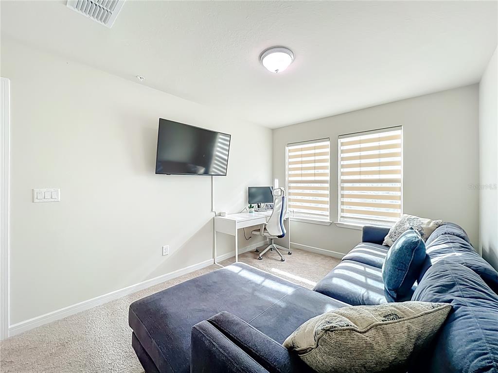 10976 Leafshore Loop Orlando, FL 32829 - Photo 34 of 70 a living room with furniture and a flat screen tv