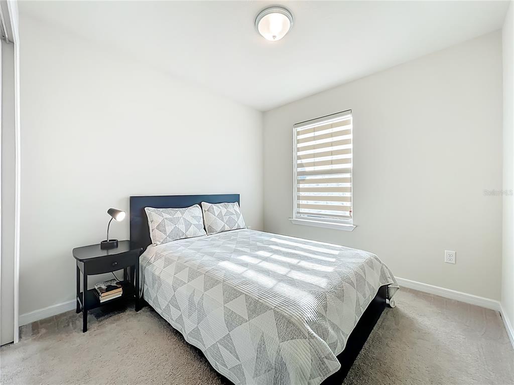 10976 Leafshore Loop Orlando, FL 32829 - Photo 38 of 70 a large bed sitting in a bedroom next to a window and a chair