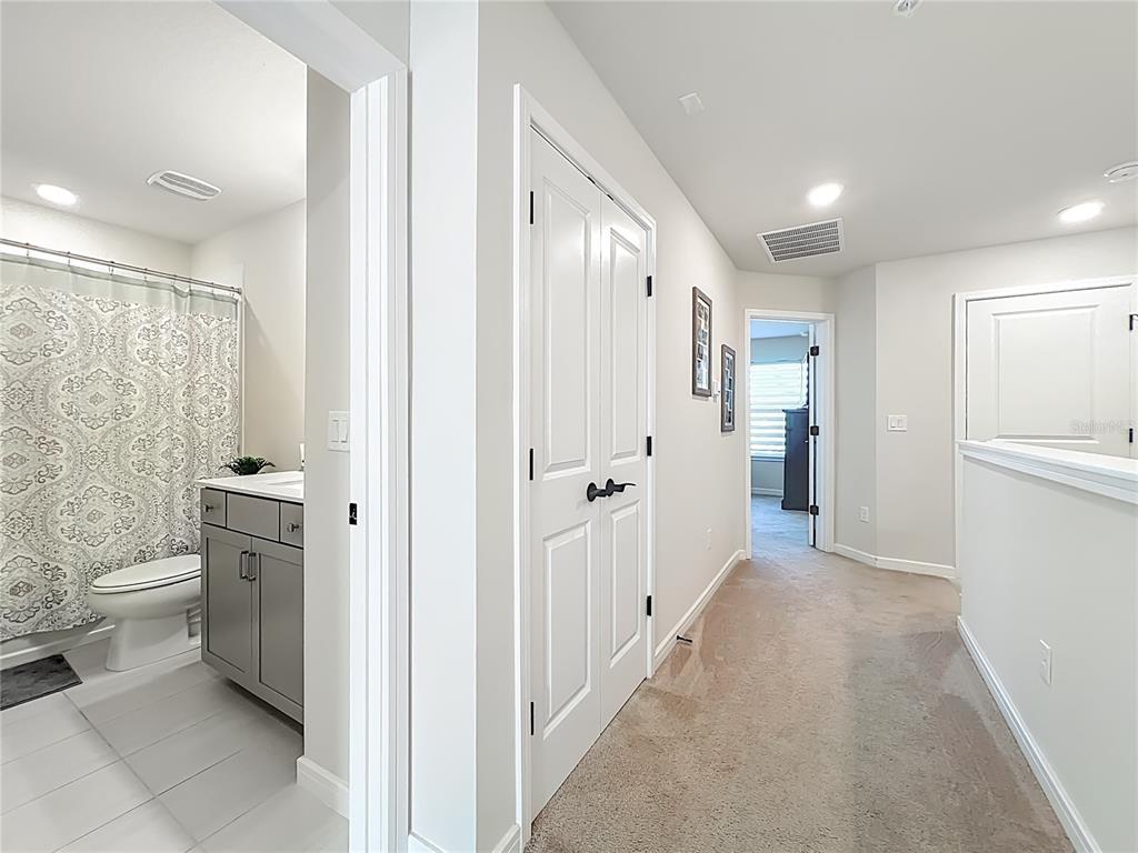 10976 Leafshore Loop Orlando, FL 32829 - Photo 40 of 70 a bathroom with a granite countertop toilet a sink and a mirror