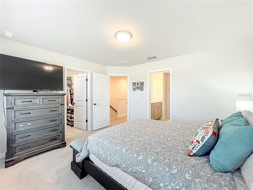 10976 Leafshore Loop Orlando, FL 32829 - Photo 44 of 70 a bedroom with a bed and flat screen tv