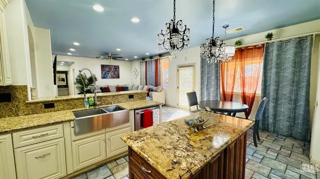 a kitchen with kitchen island granite countertop a sink stove and refrigerator
