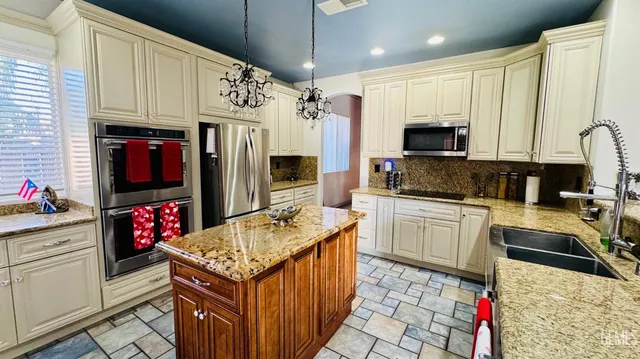a kitchen with stainless steel appliances granite countertop a sink stove and cabinets