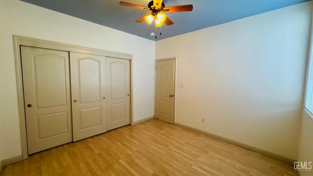 a view of an empty room and chandelier fan