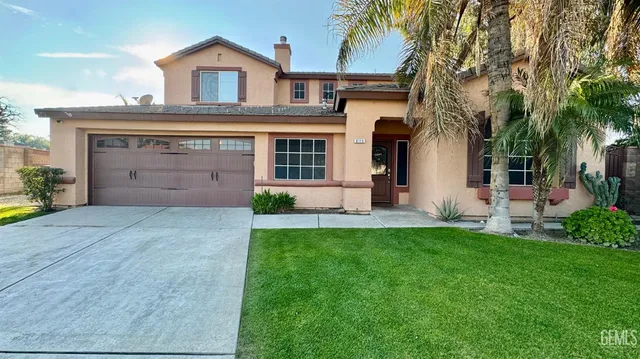 a front view of a house with a garden and yard