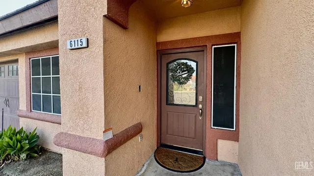 a front view of a house with a door and a potted plant