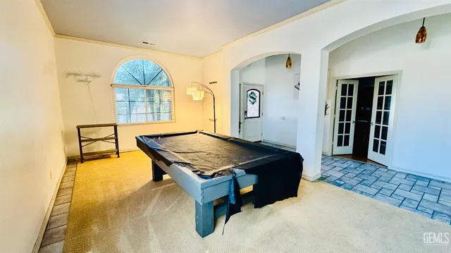 a living room with a table and paintings on the wall