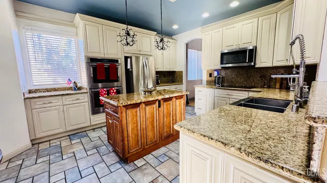a kitchen with stainless steel appliances granite countertop a sink stove and microwave