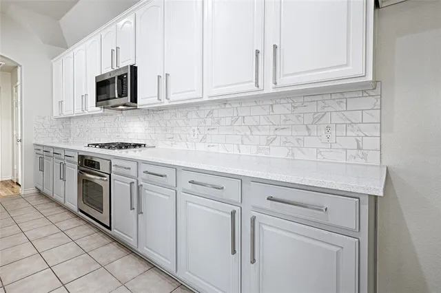a kitchen with granite countertop white cabinets stainless steel appliances and sink