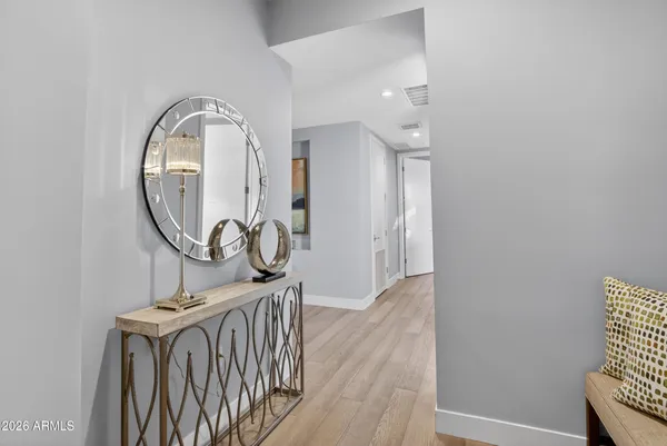 an entryway with wooden floor and mirror