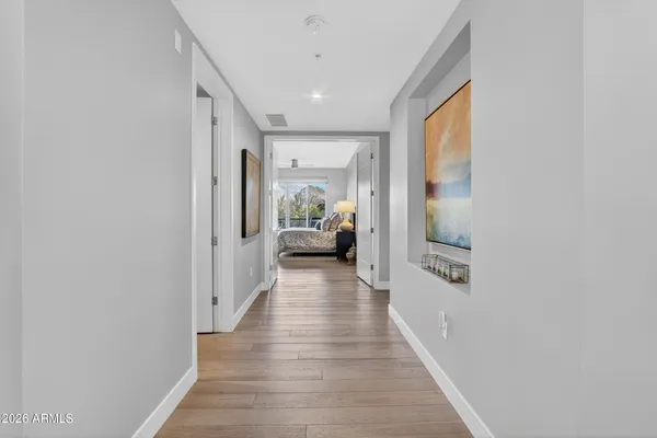 a hallway with wooden floor windows and closet
