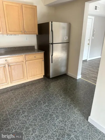 a kitchen with a refrigerator and cabinets