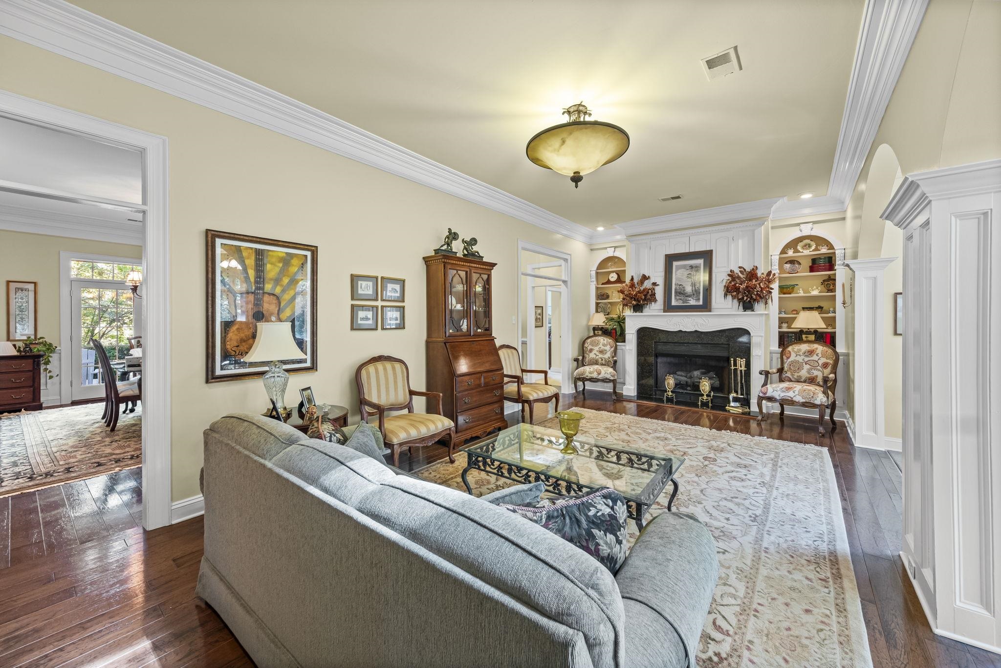 450 Cherry Road Eads, TN 38028 - Photo 10 of 24 Living room featuring ornamental molding, dark wood-type flooring, a fireplace, and arched walkways
