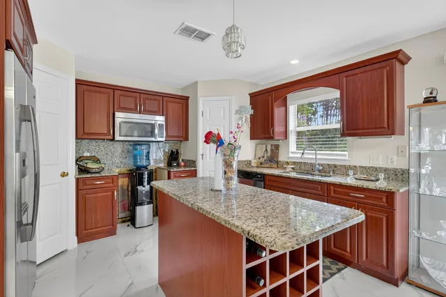 a kitchen with stainless steel appliances granite countertop a kitchen island a stove a sink dishwasher and microwave oven
