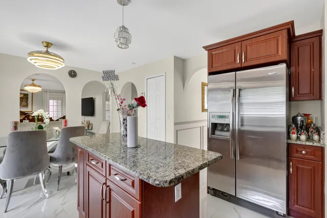 a kitchen with stainless steel appliances granite countertop a sink refrigerator and cabinets