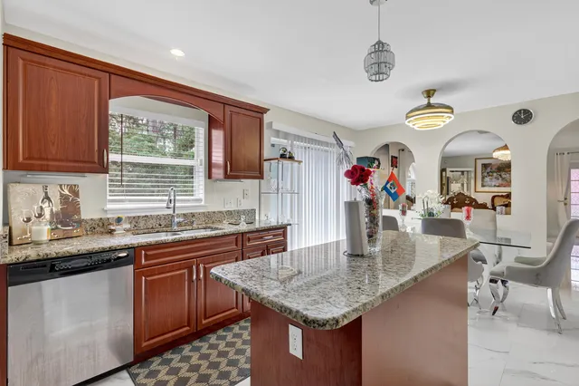 a kitchen with stainless steel appliances granite countertop a sink dishwasher and cabinets with wooden floor