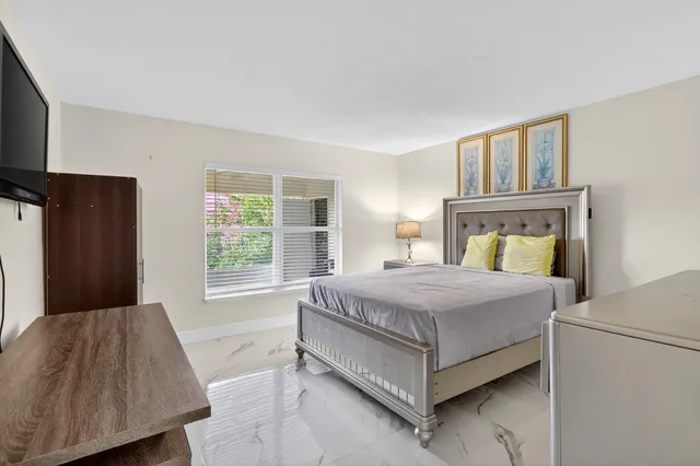 a bedroom with a bed lamp and a window