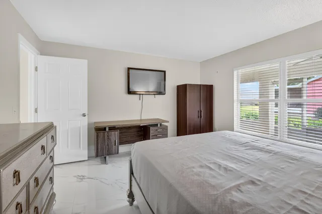 a bedroom with a bed and a flat screen tv