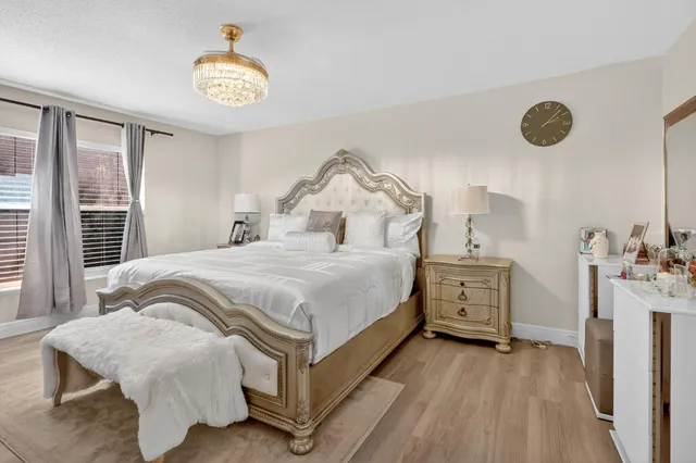 a bedroom with a bed and a chandelier