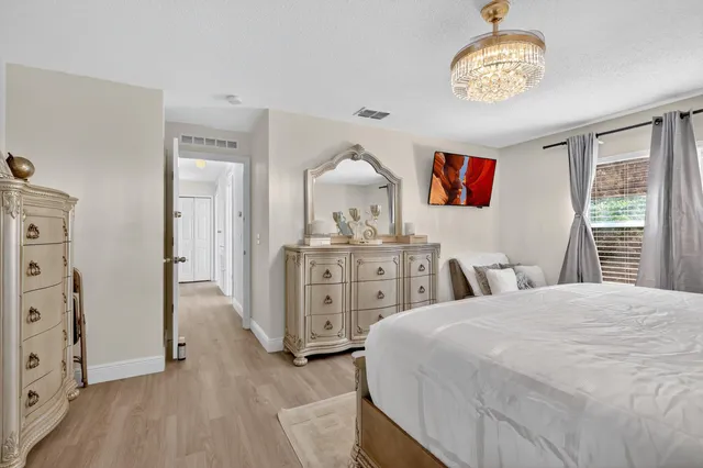 a bedroom with a bed and a chandelier