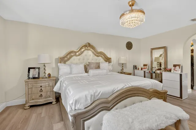 a bedroom with a bed and a chandelier