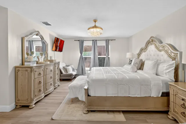 a bedroom with a bed and a chandelier