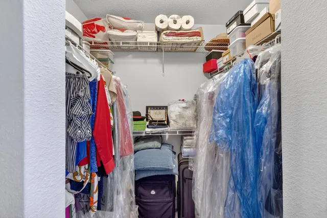 a view of walk in closet with clothes and shoes