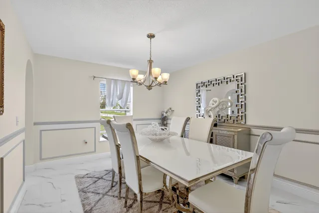 a view of a dining room with furniture and chandelier